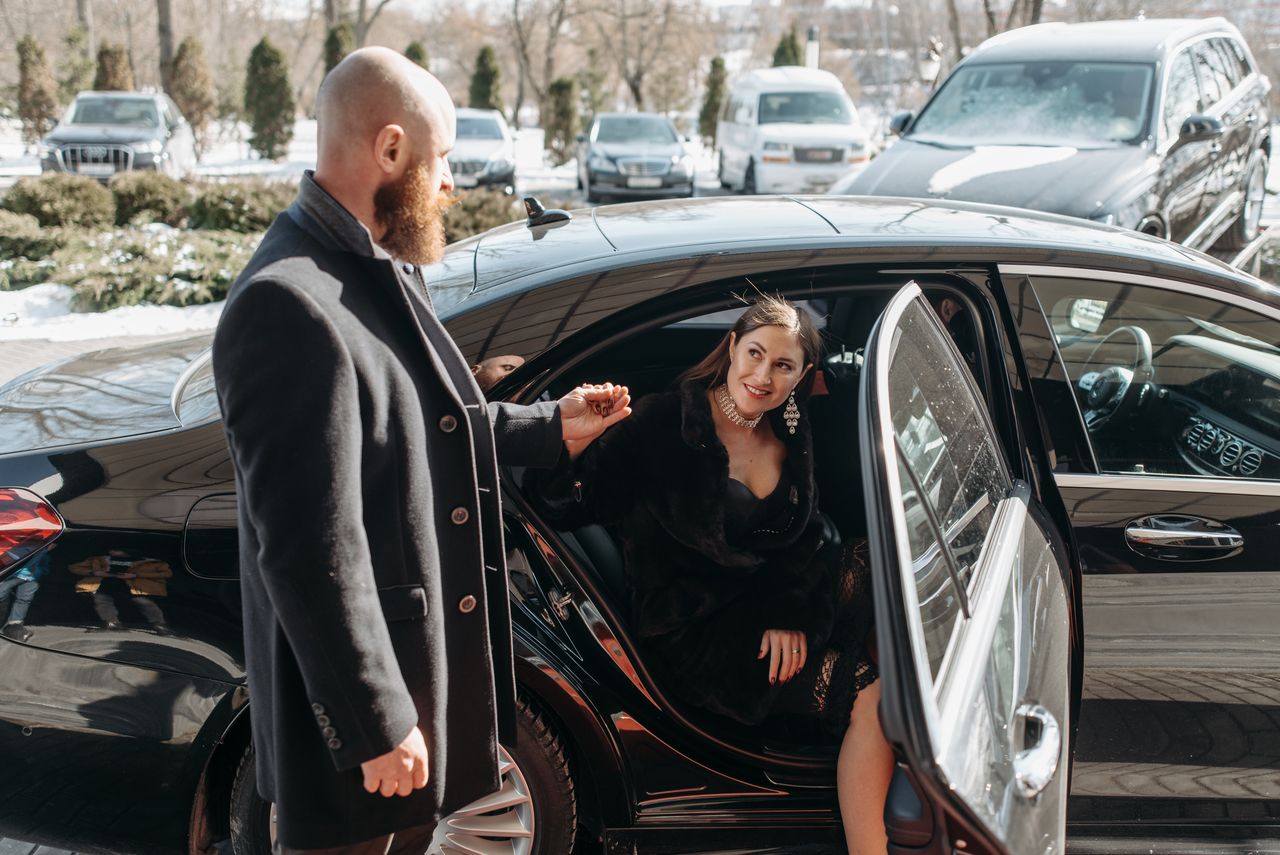 services-03 Stylish couple stepping out of a luxury black car, emphasizing elegance and sophistication.